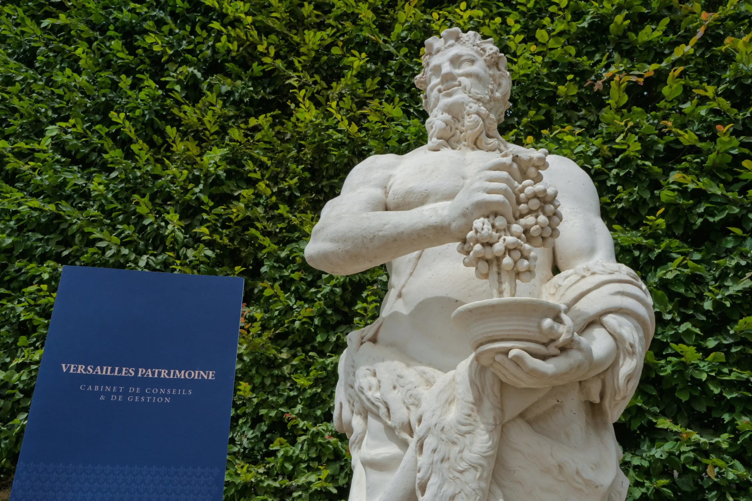 Dossier de présentation du cabinet devant une statue du parc de Versailles